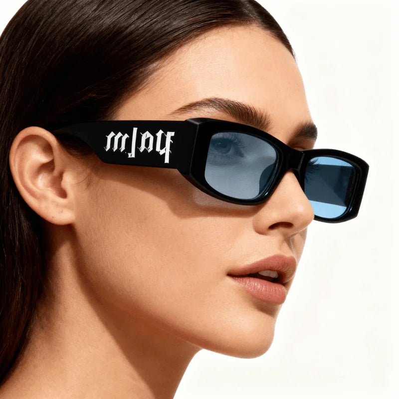 Woman wearing black rectangular sunglasses with blue lenses and bold white lettering