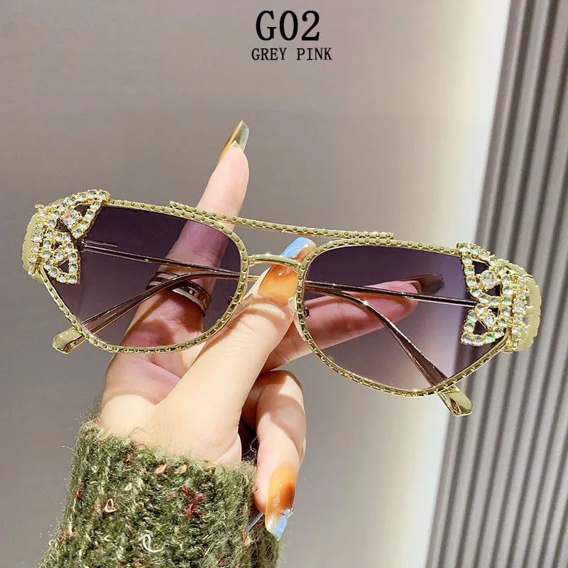 Gold-rimmed aviator sunglasses with crystal butterfly accents and grey pink gradient lenses